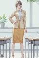 A woman in a beige suit standing in front of a classroom.